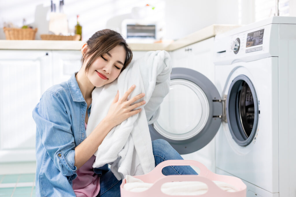 Woman hugging clean white laundry with confidence — fabric that biodegrades naturally with PERMA and CiCLO technology
