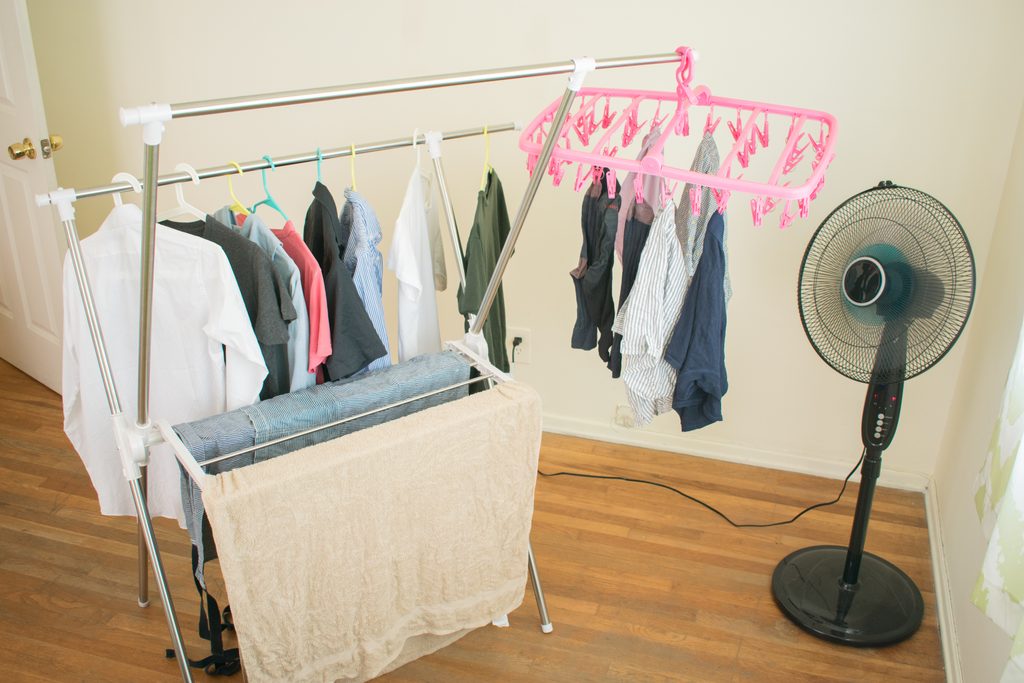 Clothes drying rack with a fan in a room, an example of rainy season laundry care at home